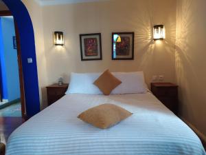舍夫沙万Hotel Gernika的卧室内的一张床位,墙上有两盏灯