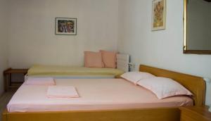 格鲁达Apartments and rooms by the sea Molunat, Dubrovnik - 17143的一间卧室配有两张带粉色和绿色床单的床