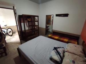 穆库热Hostel Mucugê的一间卧室配有一张床、一把椅子和镜子