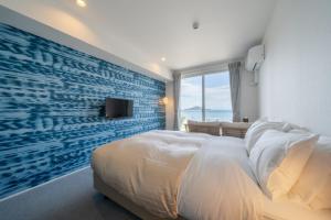 小豆岛SETOUCHI SUP RESORT - Ao -的一间卧室设有一张蓝色墙面的大床