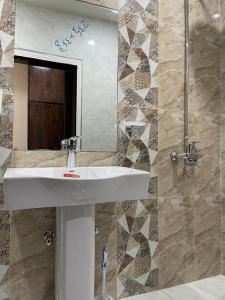 拉瓦尔品第Hotel H6的浴室设有白色水槽和镜子