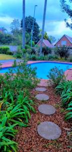 彼得马里茨堡Pmb Guest House的花园,设有游泳池旁的走道