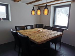 波斯基亚沃Romantic standalone 5 room cottage in Valposchiavo的一间带木桌和椅子的用餐室