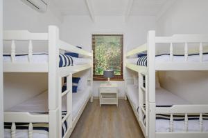 绍斯布鲁姆San Lameer Villa 2610 - 4 Bedroom Classic - 8 pax - San Lameer Rental Agency的客房设有三张双层床和一扇窗户。