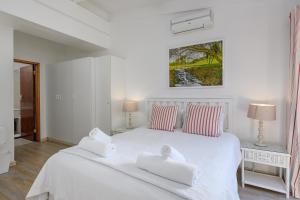 绍斯布鲁姆San Lameer Villa 2610 - 4 Bedroom Classic - 8 pax - San Lameer Rental Agency的白色卧室配有白色床和2条毛巾