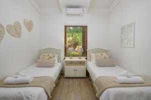 绍斯布鲁姆San Lameer Villa 2610 - 4 Bedroom Classic - 8 pax - San Lameer Rental Agency的客房设有两张单人床和一扇窗户。