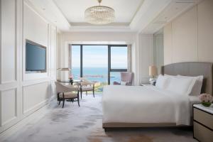 海口海口朗廷酒店的酒店客房设有一张大床,享有海景。