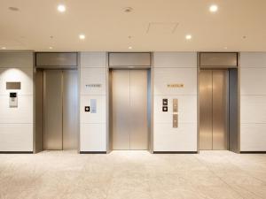 东京KEIKYU EX INN Keikyu Kamata Station的建筑物里的一排电梯