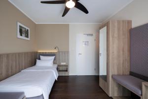 明斯特Hotel Jellentrup - Adults Only的一间卧室配有两张床和吊扇