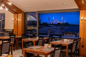 伊斯坦布尔Demiray Hotel Old City的餐厅设有木桌和大窗户。