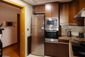 迪拜Dulive的厨房配有不锈钢用具和木柜