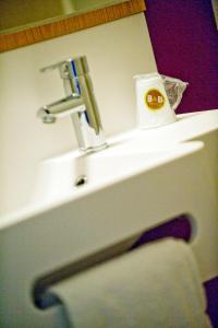 日内瓦B&B HOTEL Geneva Airport的浴室水槽配有水龙头和毛巾