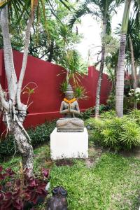 八丹拜CASA MIMBA - Seaview Private Pool Villa Padangbai的红墙前花园中的雕像