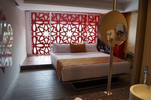 墨西哥城阿玛拉酒店的一间卧室设有一张床和一个红色的窗户