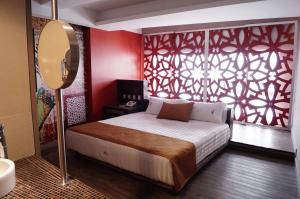 墨西哥城阿玛拉酒店的一间卧室设有一张床和红色的墙壁