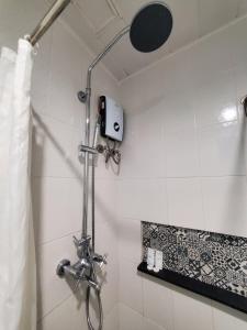 马尼拉Leez Inn Makati的浴室内配有淋浴和头顶淋浴