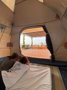 AtlitAtlit Rooftop Glamping的几个人躺在帐篷里