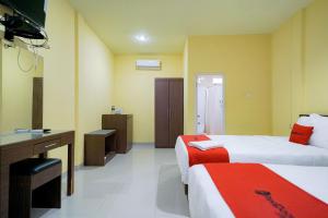 SibolgaRedDoorz Plus @ Jalan FL Lumban Tobing Sibolga的酒店客房配有两张床和一张书桌