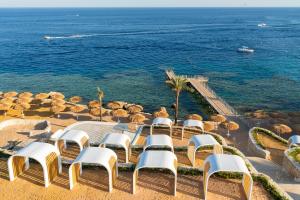沙姆沙伊赫Meraki Resort Sharm El Sheikh Adults only的一组椅子和一张桌子,海洋