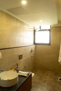 GolāghātChang's Garden & Resort的一间带水槽和卫生间的浴室以及窗户。
