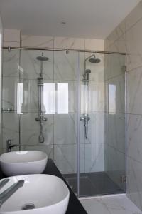 拉巴特100 Boutique Living的一间带玻璃淋浴和水槽的浴室
