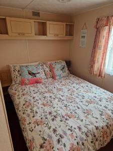 英戈尔德梅尔斯Corner pitch 4 berth caravan的小卧室配有鲜花床