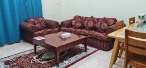 索哈尔Sadaf Hotel Apartments的客厅配有两张沙发和一张桌子