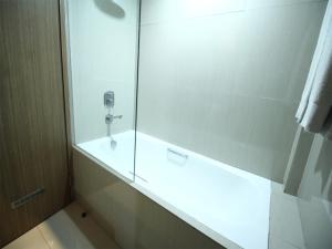 北干巴鲁龙鱼大酒店的带淋浴的浴室和玻璃门