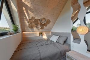 Stara RzekaOsada Stara Rzeka的配有木制天花板和窗户的客房内的一张床位