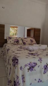 CruzMila chalé的一间卧室,床上有紫色鲜花