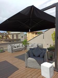 罗马Nikis Collection Trastevere的带沙发的天井顶部的黑色遮阳伞