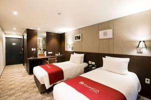 济州市华美达济州市酒店 的酒店客房配有两张床和一张书桌