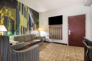 查尔斯顿Clarion Pointe Charleston - West Ashley的一间配有沙发和平面电视的酒店客房