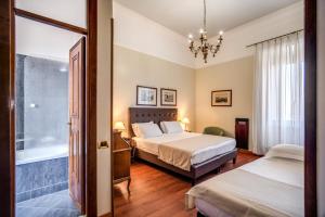 罗马Hotel Della Torre Argentina的一间卧室配有两张床和吊灯。