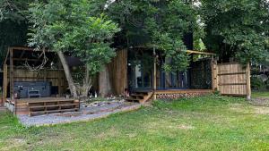 灵伍德Lynbrook Haybarn, Hot tub and outdoor kitchen, New Forest的小木屋设有围栏和一棵树