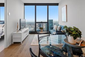 墨尔本CLLIX Australia 108 Apartments的客厅配有玻璃桌和沙发