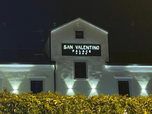 乌马格San Valentino Palace的白色的建筑,晚上有标志