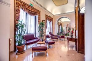 罗马Hotel Della Torre Argentina的大堂配有紫色家具和植物