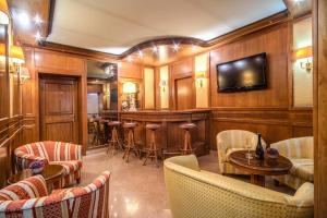 罗马Hotel Della Torre Argentina的一间酒吧,位于带椅子和桌子的房间