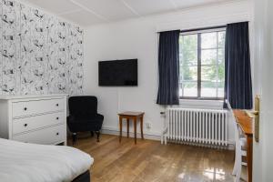 格兰纳吉尔内奥特内酒店的一间卧室配有一张床、一张书桌和一个窗户。