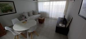 格拉纳迪利亚德亚沃纳APARTAMENTO EN EL MEDANO - ESTRELLA DEL MAR的客厅配有白色的沙发、桌子和椅子