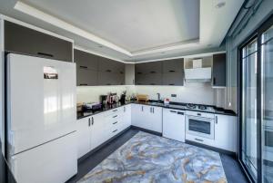 费特希耶Villa Ada的一间厨房,配有白色的橱柜和大窗户