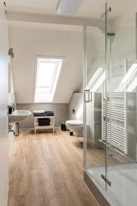 格拉登巴赫Suite Appartements Da Giovanni的一间带玻璃淋浴和水槽的浴室