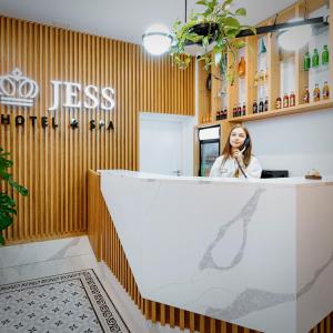 华沙Jess Hotel & Spa Warsaw Old Town的坐在餐厅接待台的女人