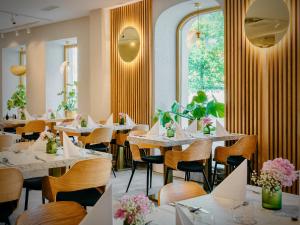 华沙Jess Hotel & Spa Warsaw Old Town的餐厅设有白色的桌椅和窗户。