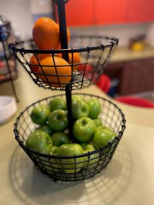 金斯顿Mother Earth Motor Lodge的柜台上一篮绿色苹果和橙子
