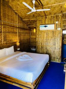 古瓦哈提Tridhara HomeStay的稻草小屋内一间卧室,配有一张床