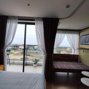绥和市Beach apartment apec Phú Yên的一间卧室设有一张床和一个大窗户
