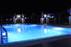 北尼科西亚Sky Roof Hotel的夜间大型蓝色游泳池,灯光照亮