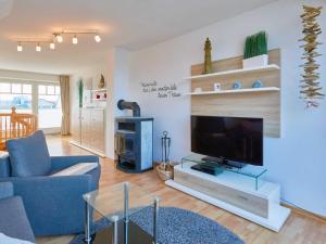 宾茨Apartmenthaus Jahreszeiten - Meerblick-Fewo 28的客厅配有蓝色的沙发和电视